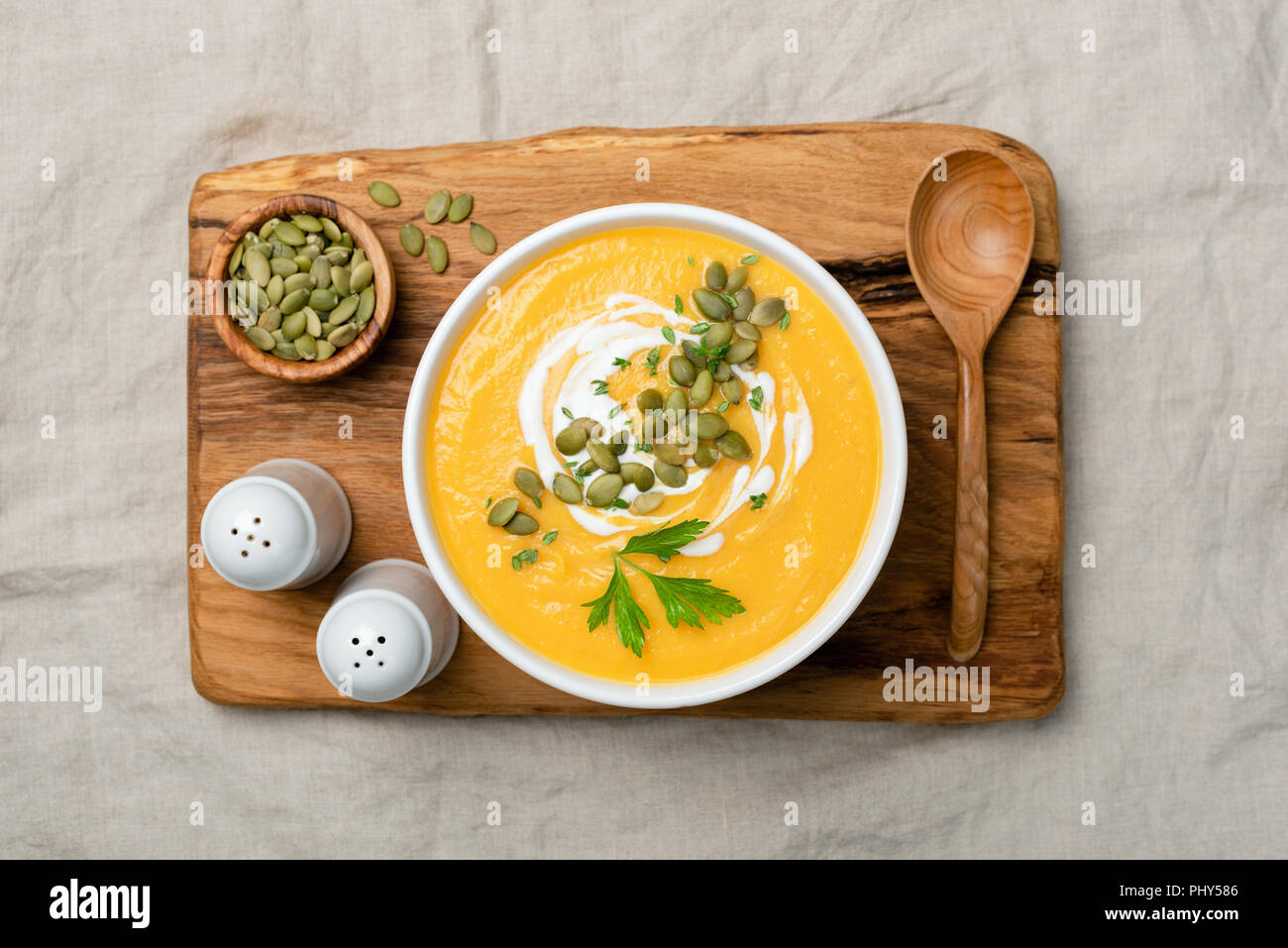 Crema di zucca zuppa su legno scheda servente. Vista superiore Foto Stock