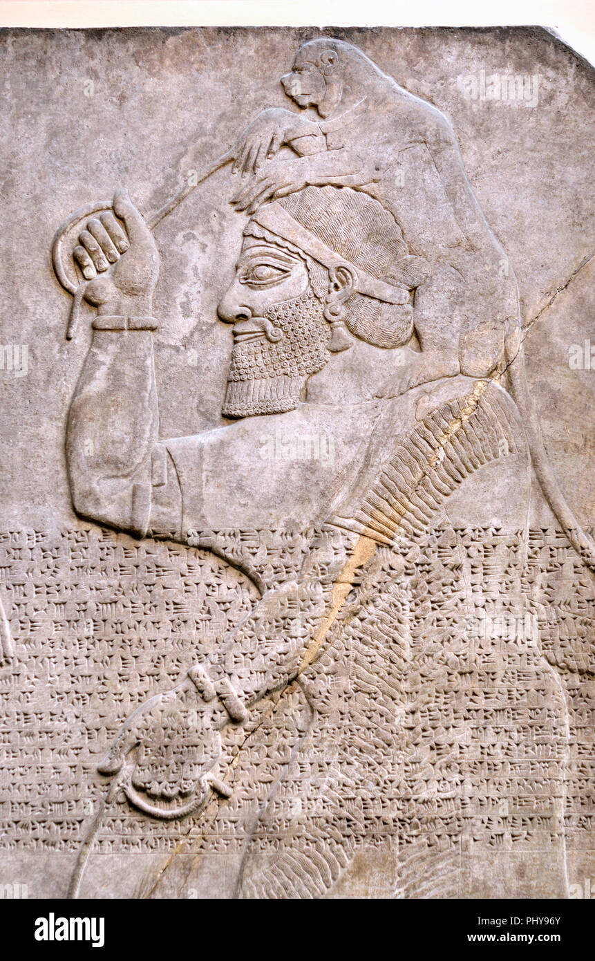 Vecchio assiro scrittura cuneiforme su un pannello di pietra da Nimrud, a nord ovest di Palazzo, (c865-860BC) di un tributo-portatore portando le scimmie per gli Assiri Kin Foto Stock