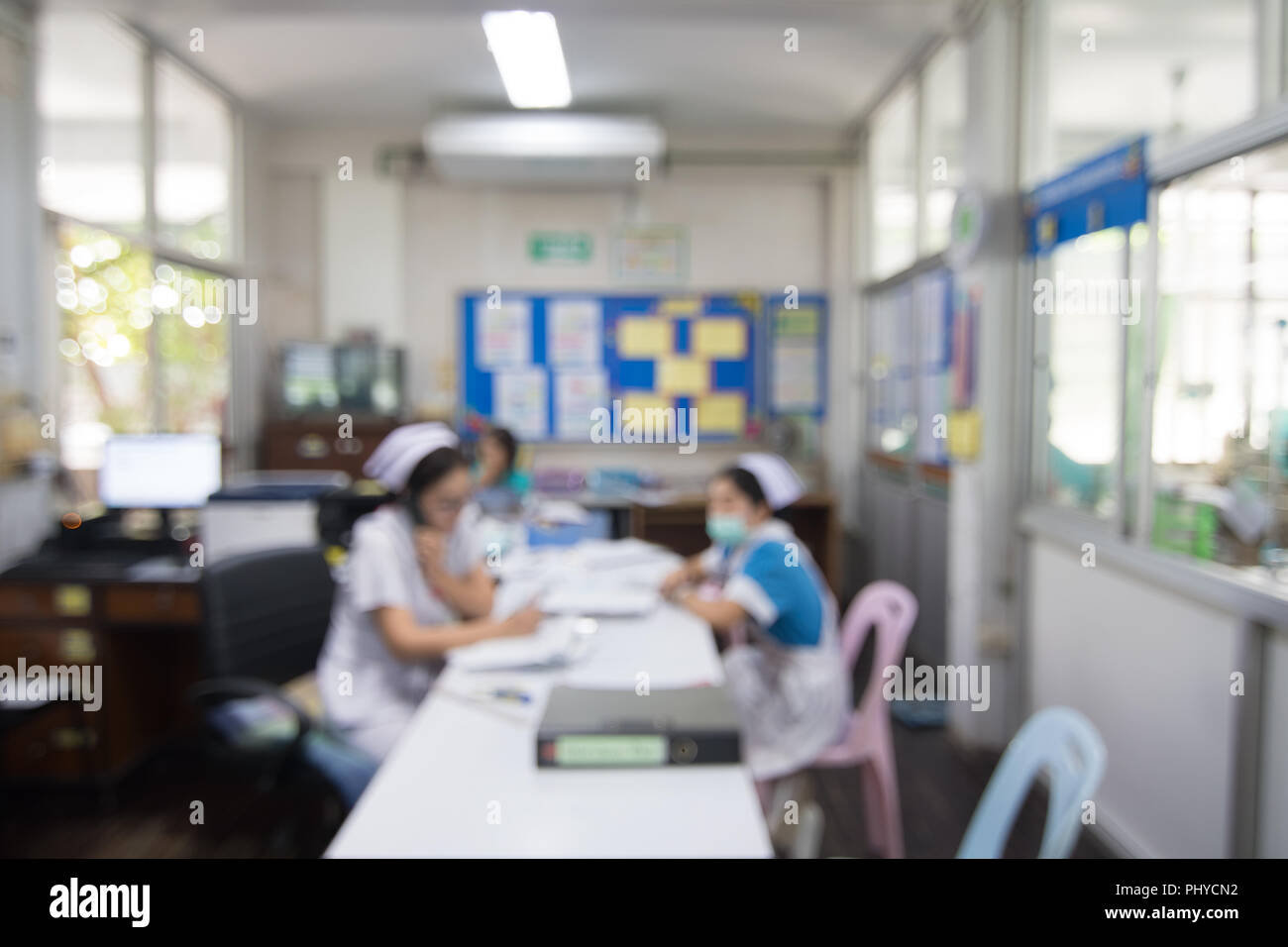 Sfocatura dello sfondo astratto infermieri in bianco uniforme lavorando dietro la stazione di infermiere in Thailandia. Foto Stock