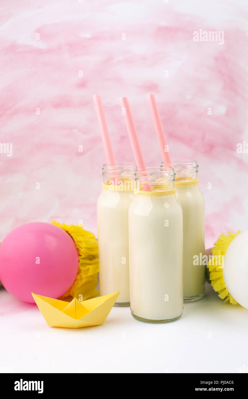 Baby doccia tavolo decorativo con spazio copia, rosa bambina stivaletti e bottiglie di latte in background color pastello, idea di bambino, doccia decor Foto Stock
