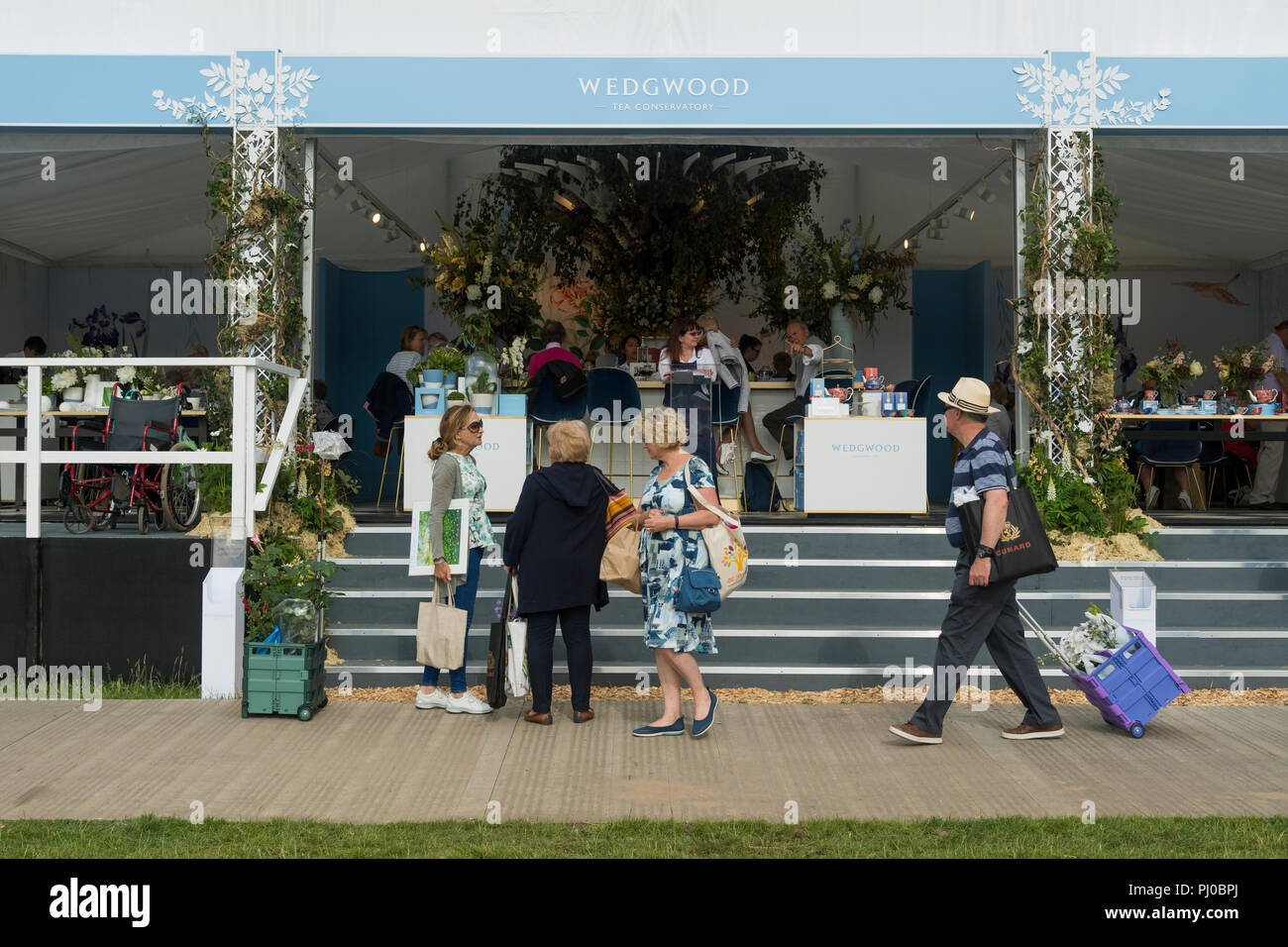 Persone a showground, passato a piedi in piedi o seduto in Wedgewood tendone ristoro - RHS Chatsworth Flower Show, Derbyshire, Inghilterra, Regno Unito. Foto Stock