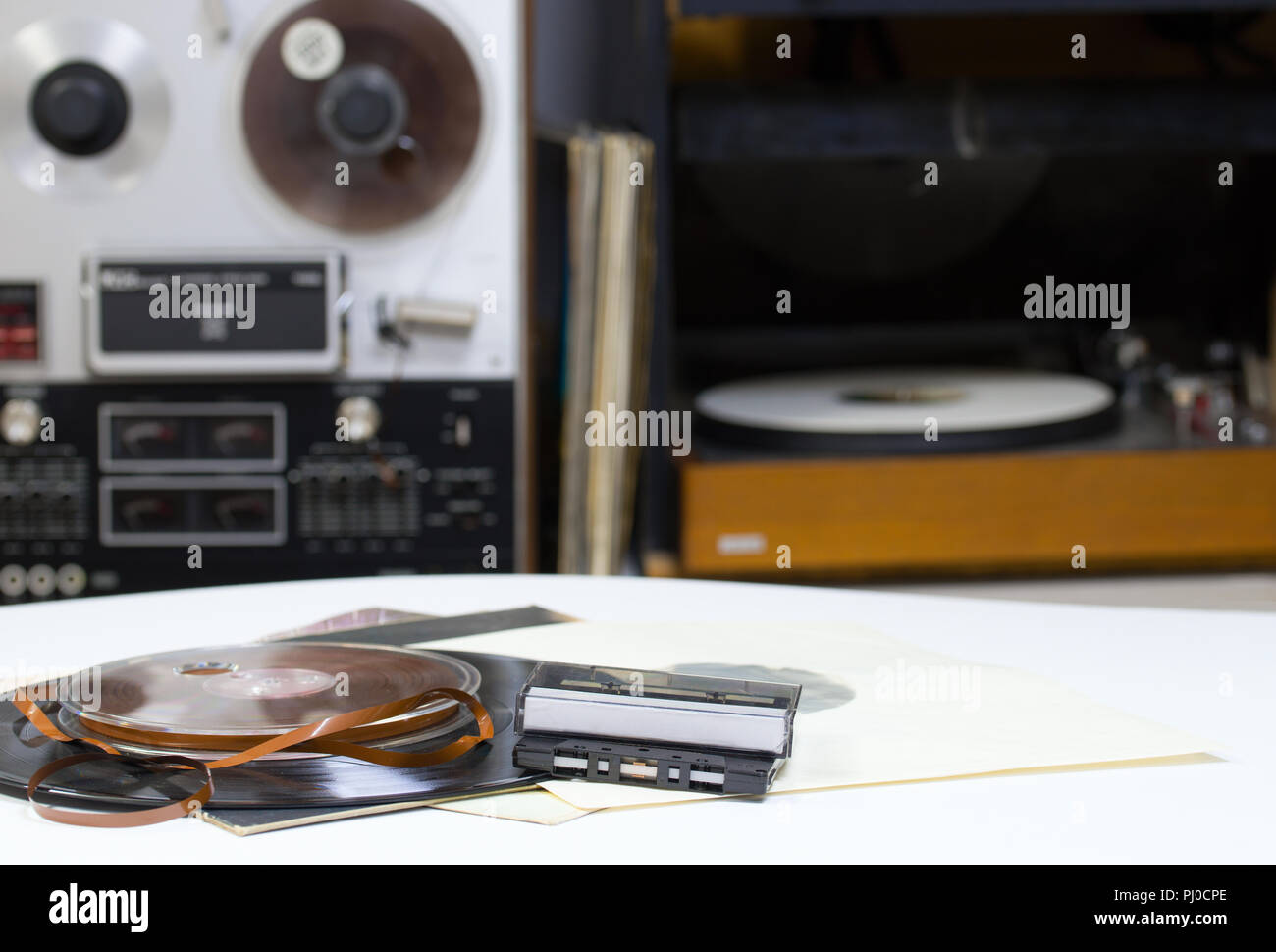 Dischi in Vinile con copia spazio nella parte anteriore di una raccolta di album titoli fittizia. Aspo registratore a nastro. Audio cassetes toccare. Foto Stock