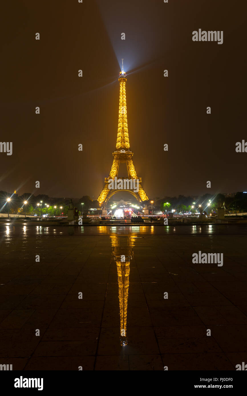 La torre Eiffel di notte con la riflessione sul pavimento bagnato Foto Stock