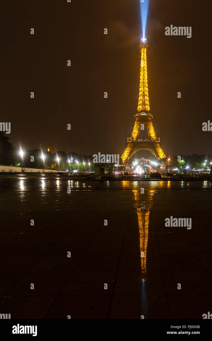 La torre Eiffel di notte con la riflessione sul pavimento bagnato Foto Stock