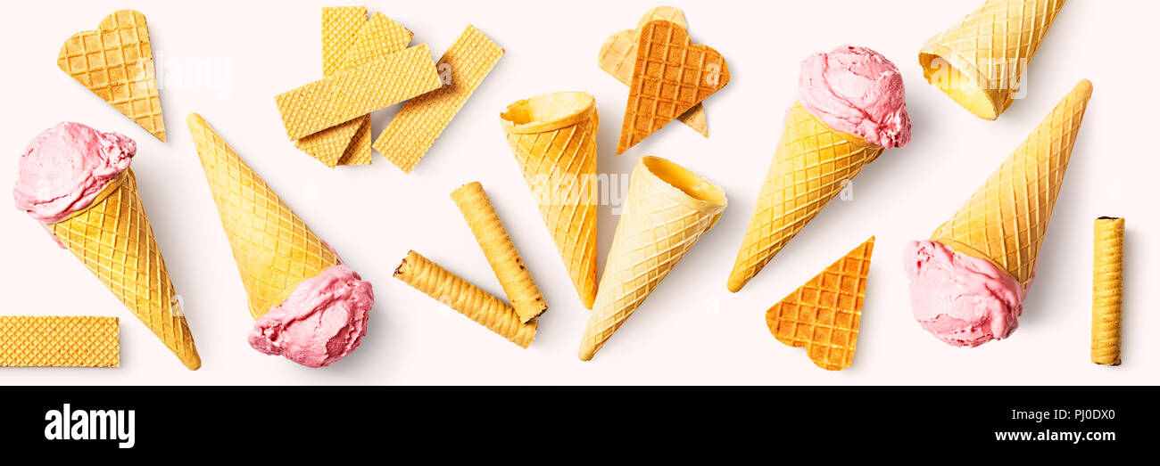 Gelato alla fragola con cono di cialda collezione. Dolce con composizione. Design banner panoramico isolato su sfondo rosa. Piatto, laici vista superiore Foto Stock