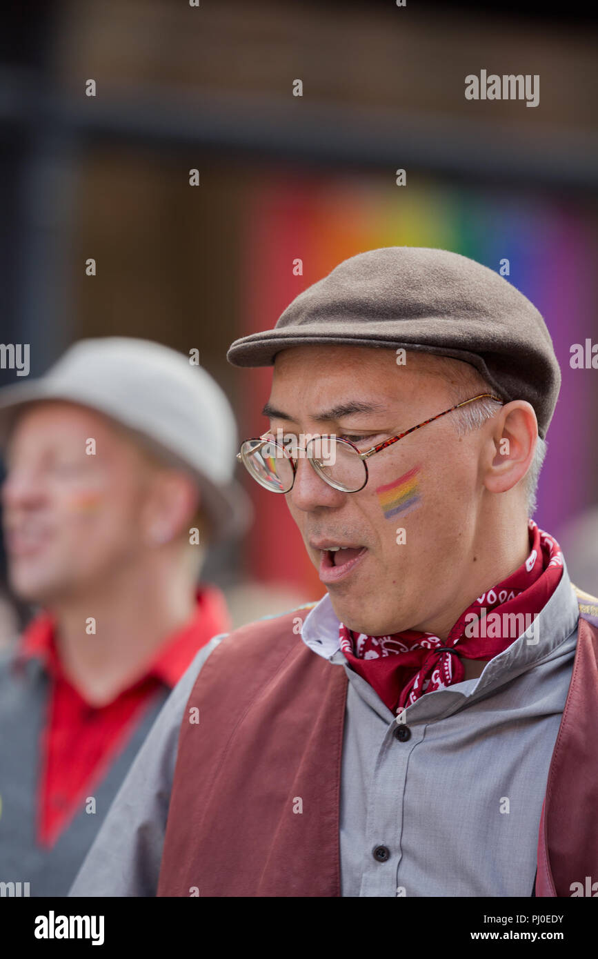 Un uomo in un tappo piatto prendendo parte al 2018 Manchester Pride Parade. Foto Stock