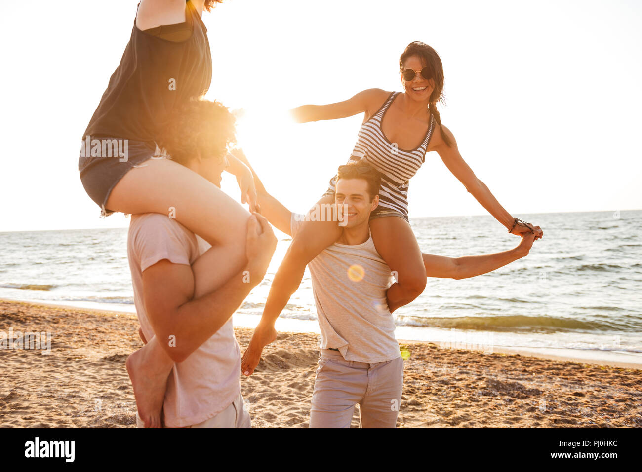 Foto di felice gruppo di amici coppie amorevole passeggiate all'aperto sulla spiaggia di divertimento. Foto Stock