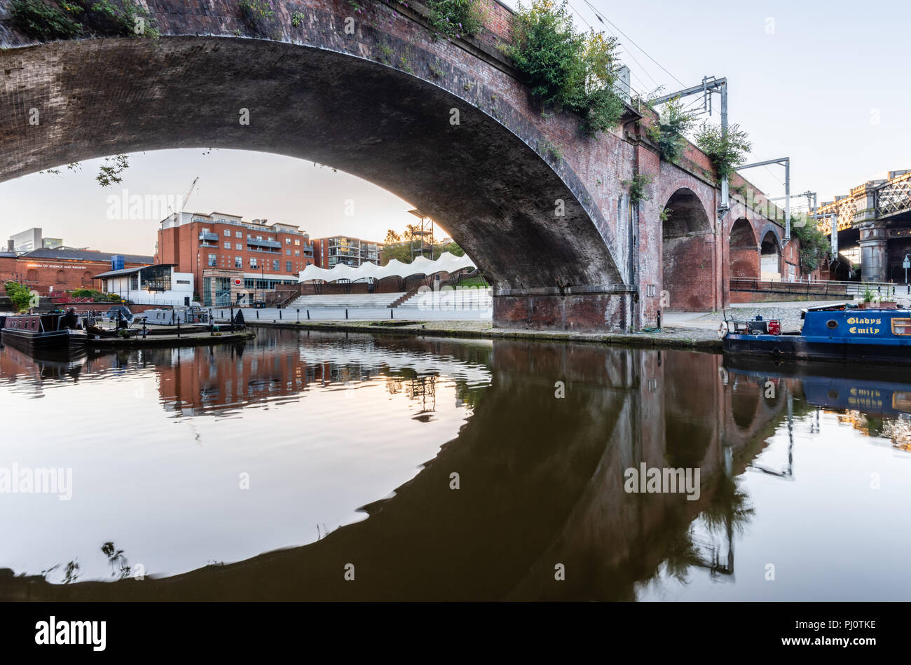 Vista dalla strada alzaia accanto al Bridgewater Canal attraverso il Castlefield viadotto e ponte verso il Castlefield ciotola in Manchester Foto Stock