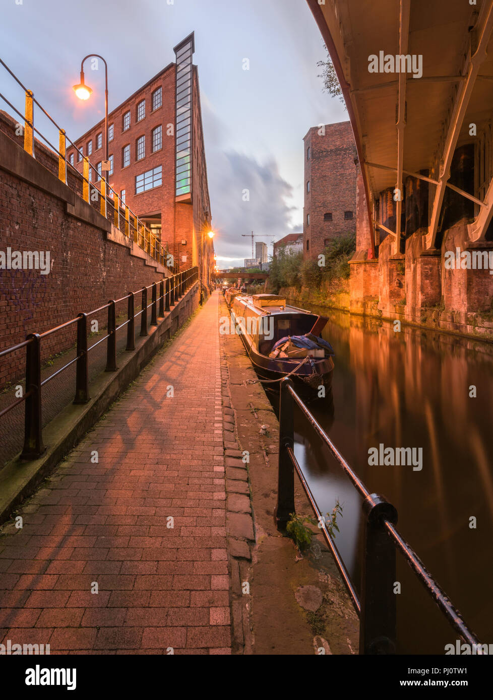 Visualizzazione verticale dall'alzaia accanto a Rochdale Canal di notte, guardando indietro verso il bacino di Castlefield Foto Stock