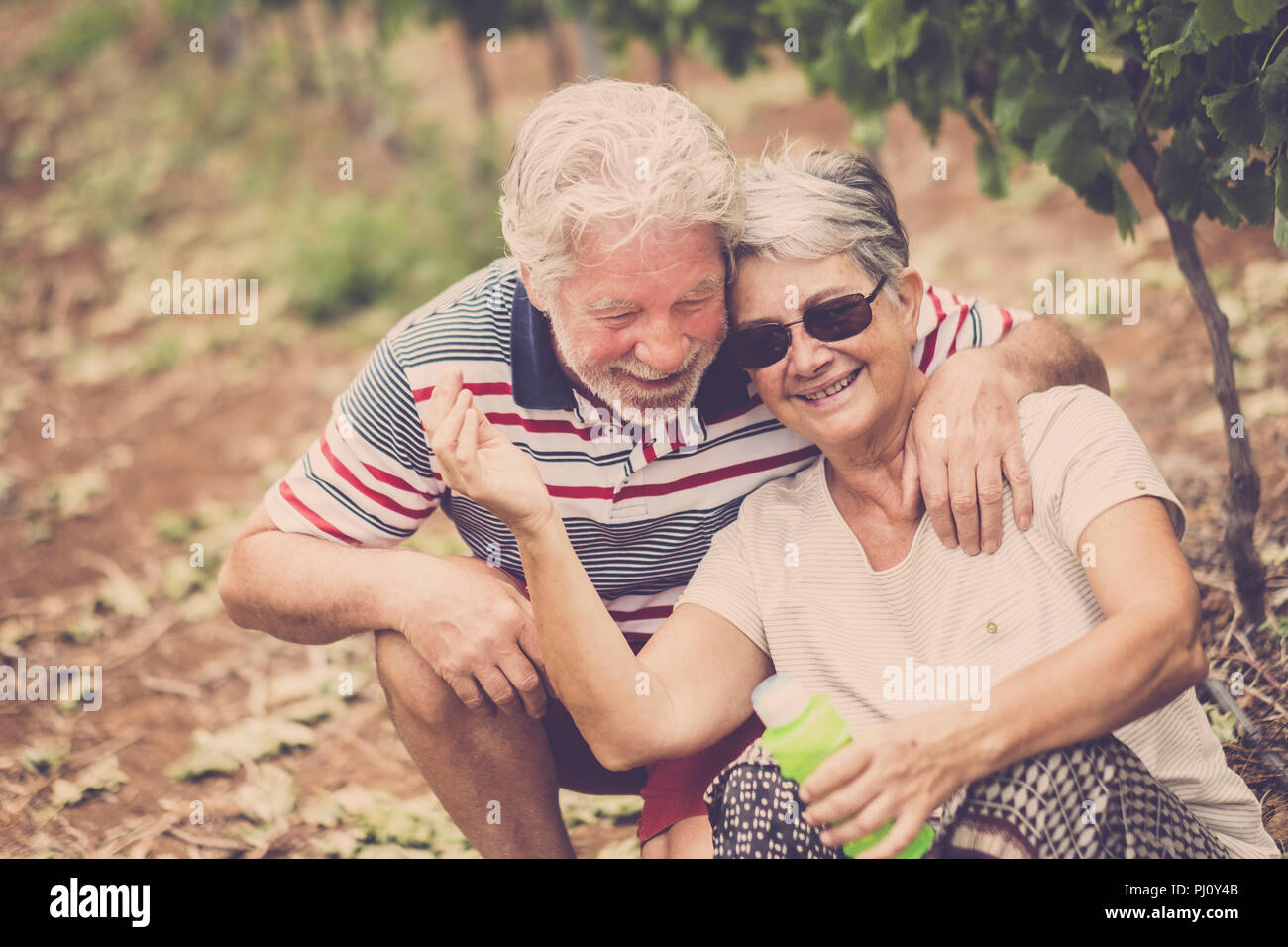 Senior adulto giovane ridere in felicità.. Insieme per sempre a giocare con le bolle di sapone nel cortile esterno di attività per il tempo libero. rimanere giovani concetto e Foto Stock