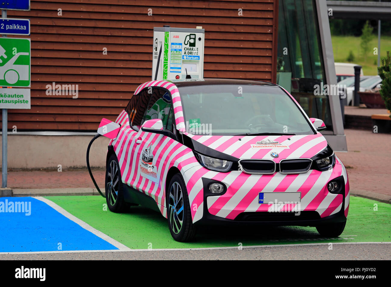 Salo, Finlandia - 21 Giugno 2018: rosa e bianca a strisce BMW auto elettrica Fishermans amico in carica a carica della batteria punto. Foto Stock