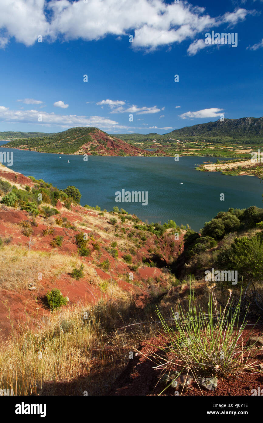 Il lago di Salagou nel sud della Francia, circondato da colore rosso Permiano depositi, i cosiddetti "ruffes', argilloso ricco di sedimenti in ossido di ferro Foto Stock