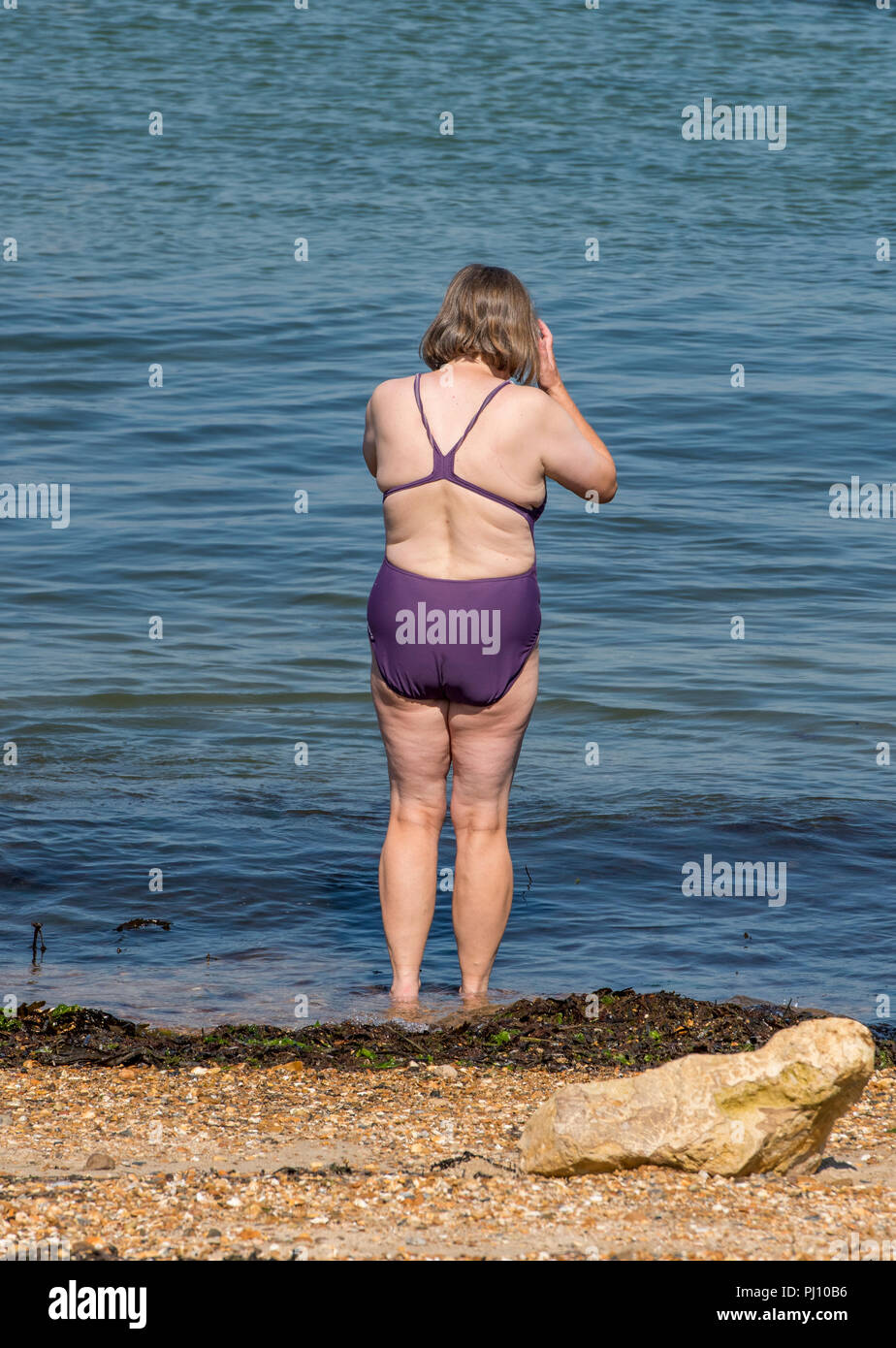 Donna anziana in costume da bagno circa a nuotare in mare permanente sulla  spiaggia Foto stock - Alamy