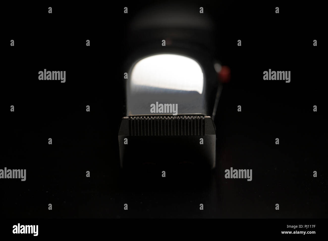 Rifinitore di grooming close up. Chrome riflettente rasoio elettrico su sfondo nero. Foto Stock