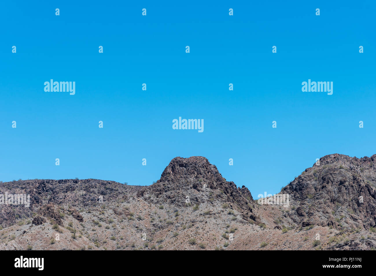 Cima rocciosa sotto il luminoso cielo blu. Foto Stock