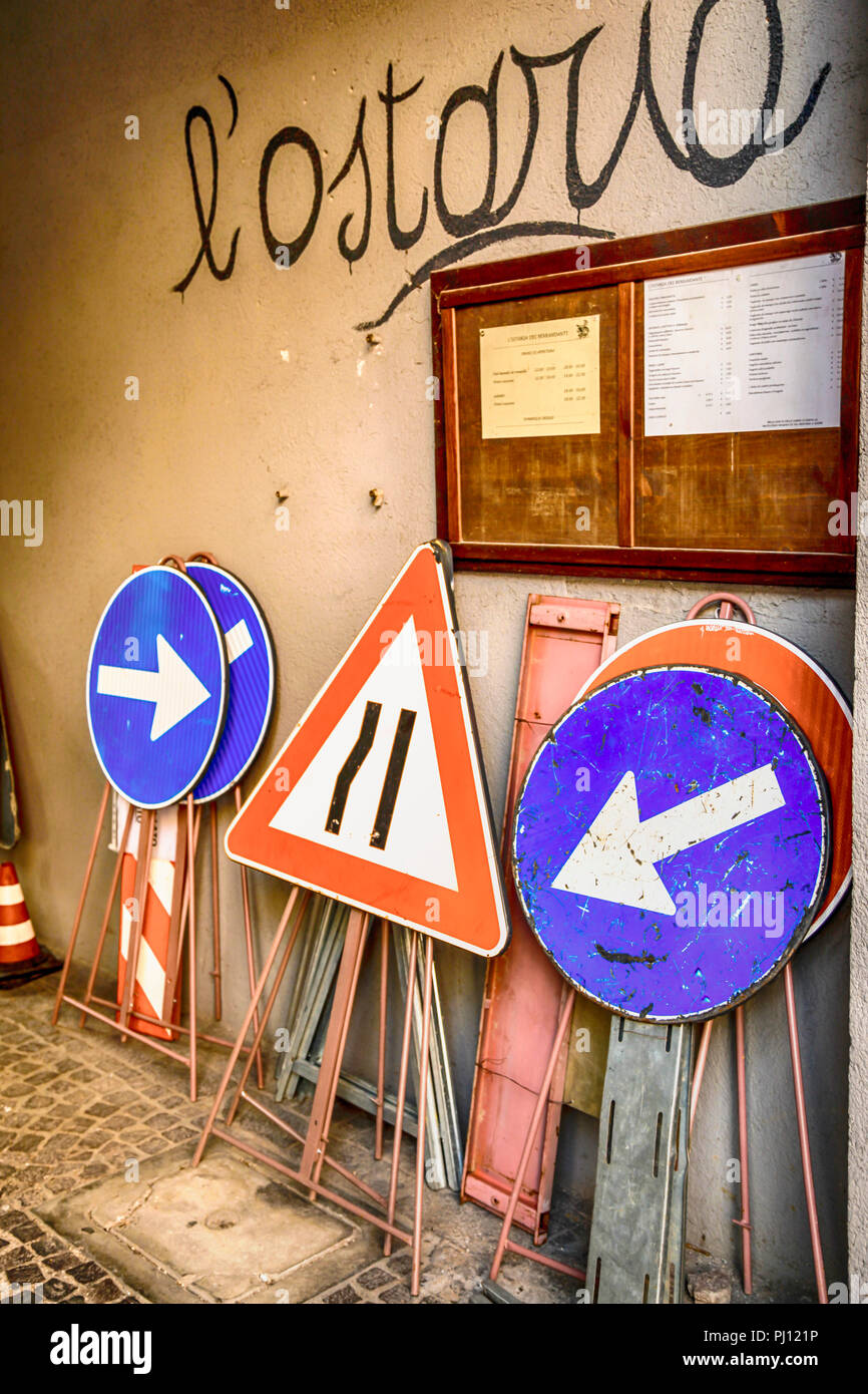 Gruppo di strada portatile segni di riparazione appoggiato contro una parete a Udine, Italia Foto Stock