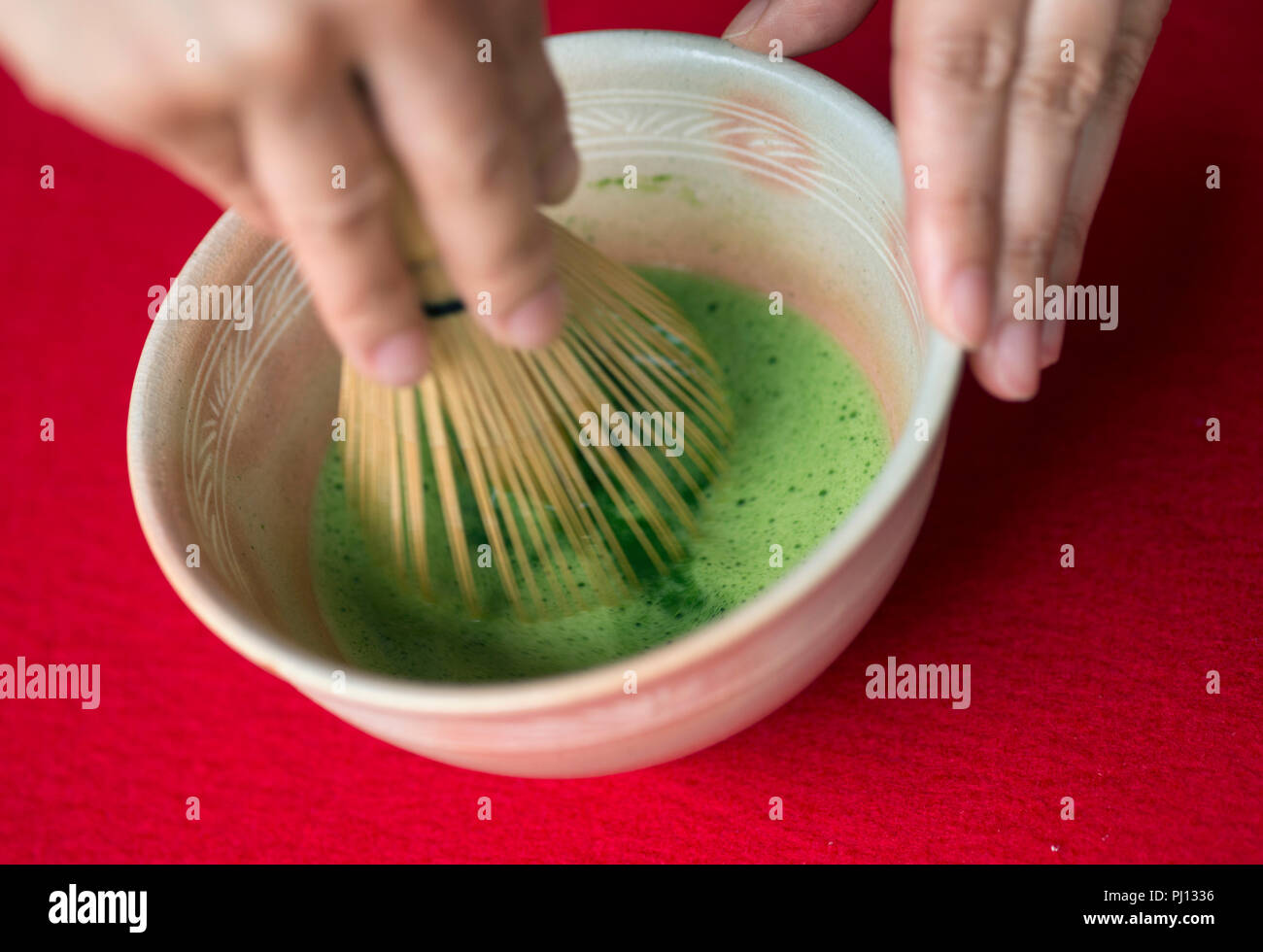 Un addetto utilizza un Takayama tè chasen Frusta per mescolare tè verde Matcha all'interno di Takayama Chikurinen a Takayama distretto di Ikoma Città, Prefettura di Nara, Ja Foto Stock