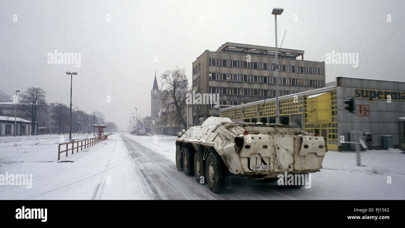 5 Marzo 1993 durante l'assedio di Sarajevo: un Nazioni Unite ucraino BTR-80 teste APC west nella neve su Sniper Alley. Fino a venire è la Chiesa della Santissima Trinità. Foto Stock