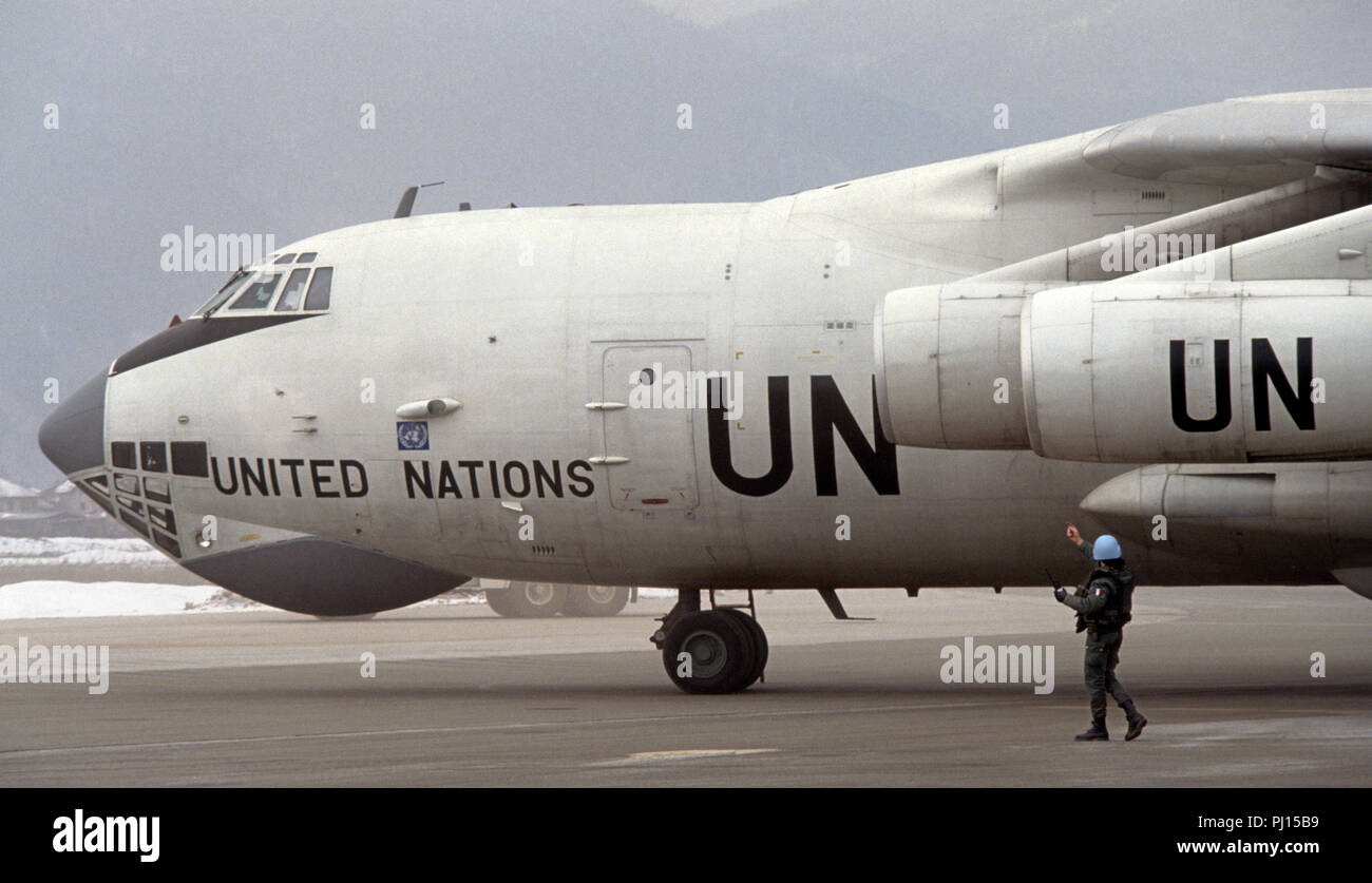 8 Marzo 1993 durante l'assedio di Sarajevo: presso l'aeroporto di Sarajevo, un francese soldato ONU dirige il pilota delle Nazioni Unite di un Ilyushin Il-76 a getto di trasporto che ha appena sbarcati. Foto Stock