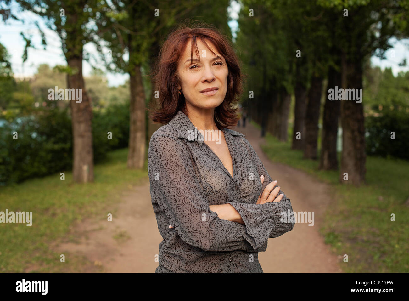 Donna matura passeggiate nel parco estivo all'aperto Foto Stock