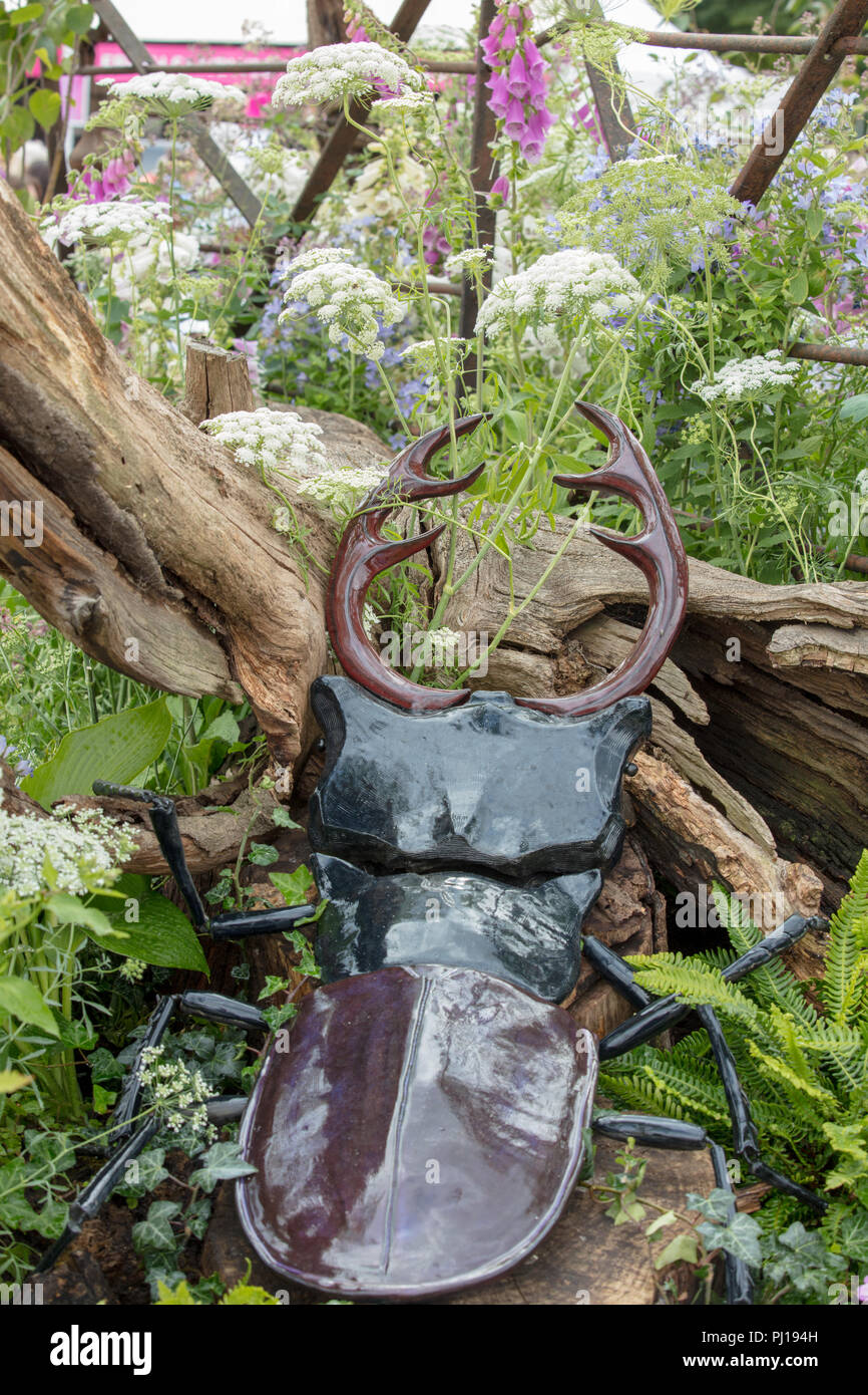 RHS Hampton Court Flower Show 2018. Rappresentanza, scultura di una lucida stag beetle con il gigante antere in ecologico naturale ambiente boschivo. Foto Stock