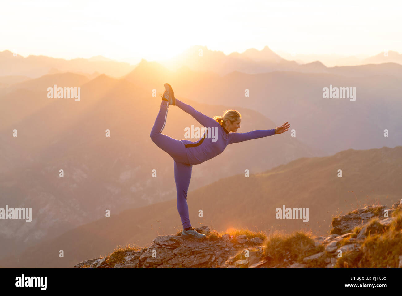 Donna facendo prua permanente pone sul crinale di Sunrise, Gastein, Salisburgo, Austria Foto Stock