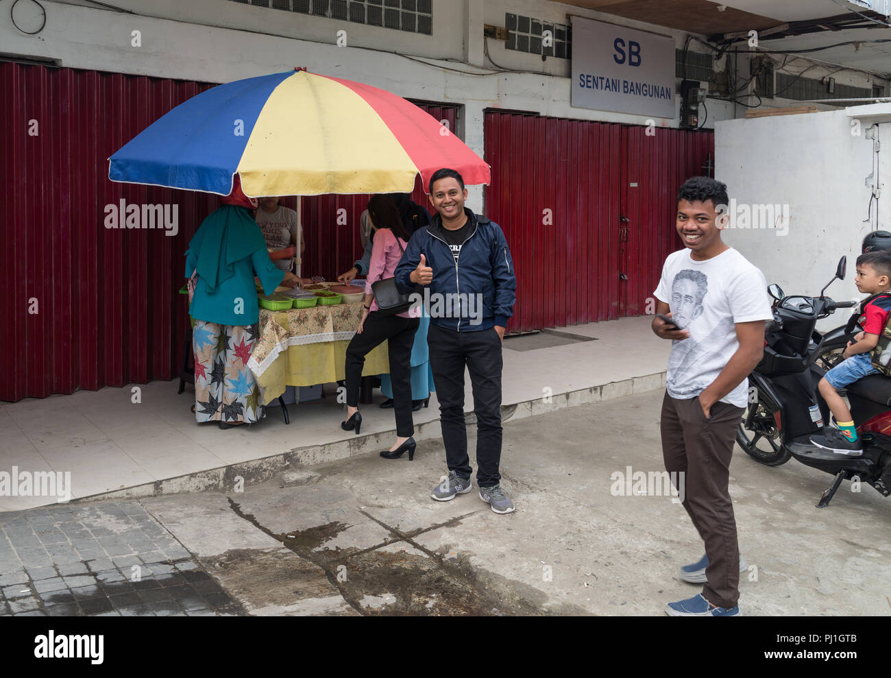 Gente amichevole in una strada laterale di stallo alimentare. Sentani, Jayapura, Indonesia. Foto Stock