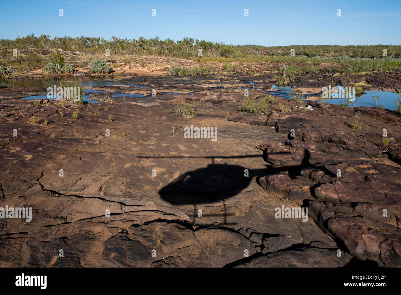 Australia, Western Australia Kimberley, Hunter River regione. Fiume Mitchell Plateau, ombra di escursioni in elicottero telecomando sul sito di atterraggio. Foto Stock