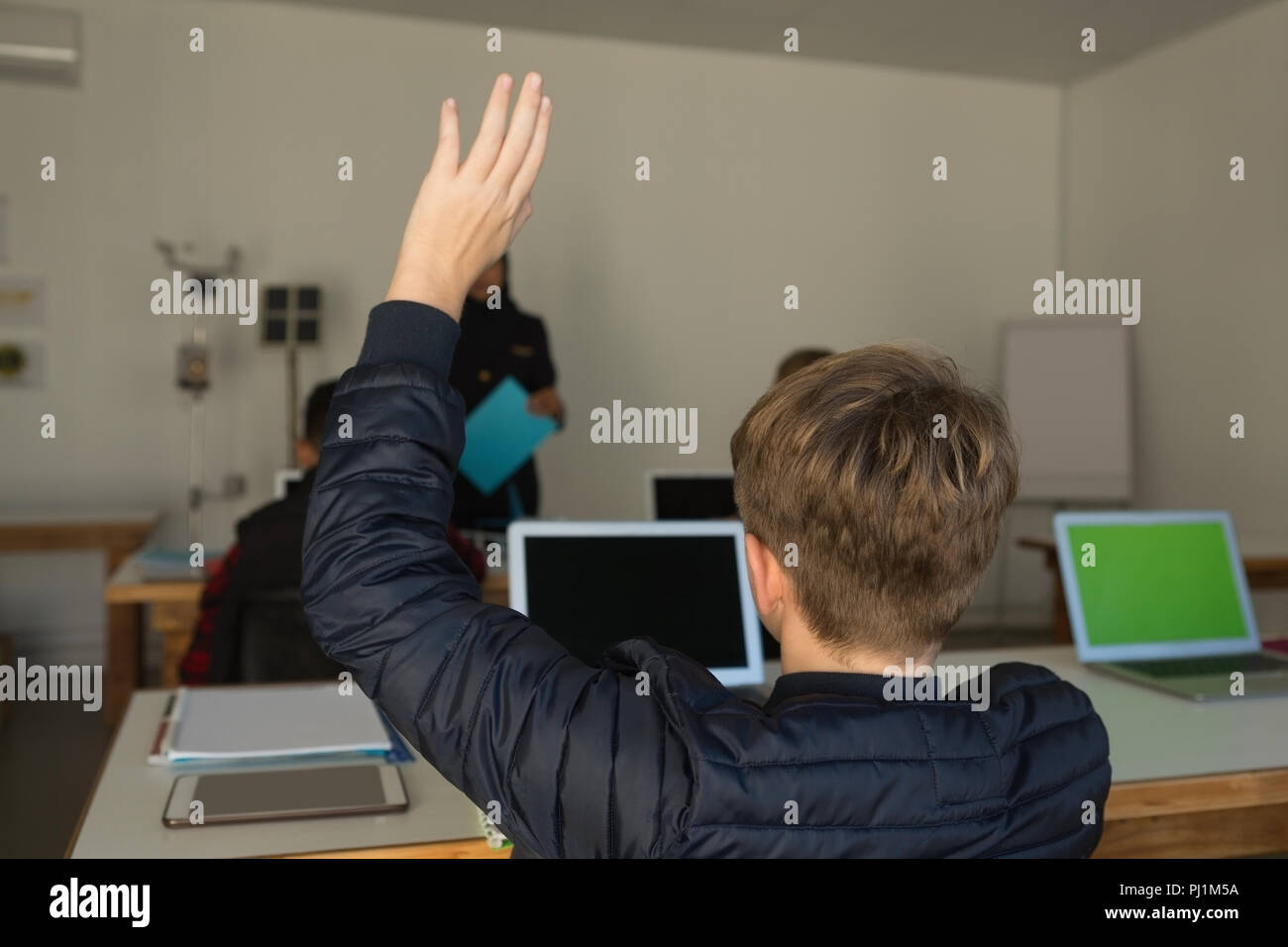Studente alzando la mano per chiedere a query Foto Stock