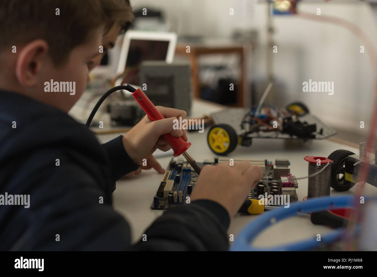 Kid lavorando su un progetto di istituto di formazione Foto Stock