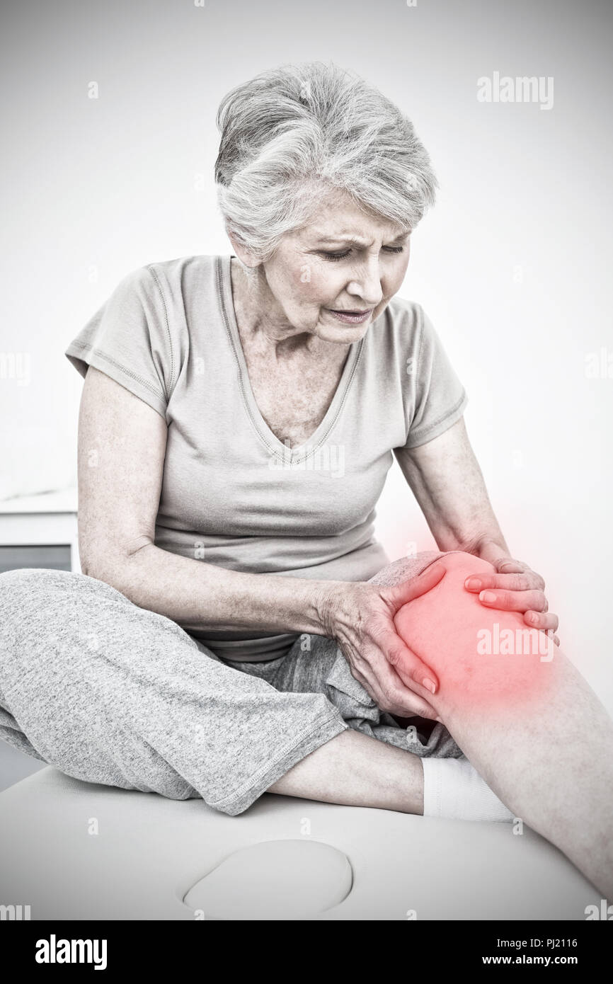 Immagine composita di senior donna con le sue mani su di un ginocchio doloroso Foto Stock