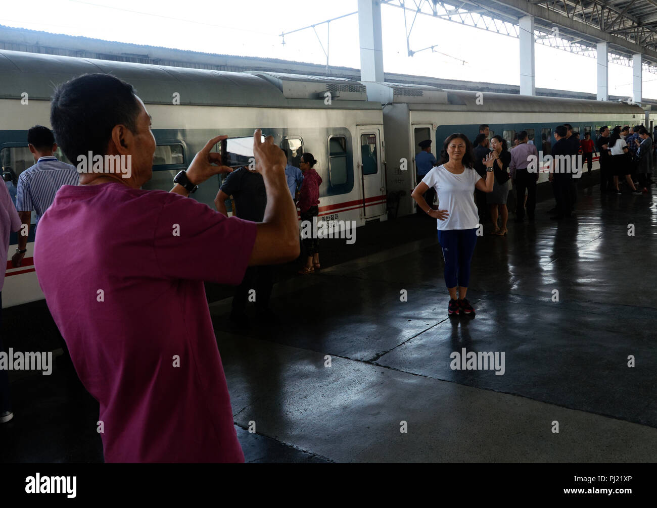 Passeggeri intorno di fresatura e scattare fotografie su Pyongyang stazione ferroviaria piattaforma come essi attendono per lasciare la Corea del Nord in treno a Dandong. Foto Stock