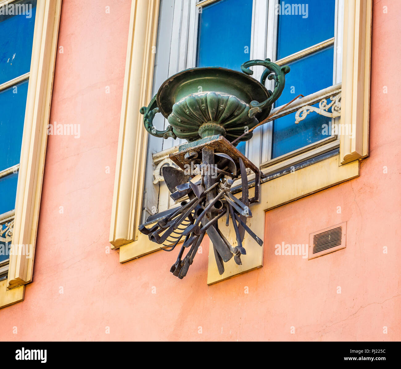 Ornati di fiori di metallo pot con selezione di metallo strumenti workmans pendente al di sotto di Troyes, l'Aube in Francia il 31 agosto 2018 Foto Stock