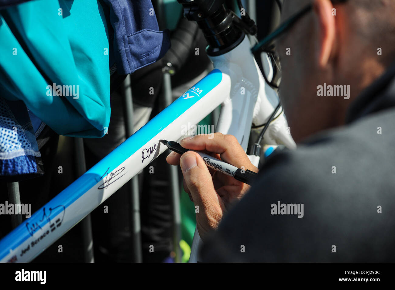 Cranbrook, Devon, Regno Unito, 3 settembre 2018. Il tour della Gran Bretagna, stadio 2 Cranbrook a Barnstaple. Sir David Brailsford, General Manager del team SKY, segni di un fan bike al di fuori del team autobus in anticipo di fase 2 in Cranbrook. Credito: David Partridge/Alamy Live News Foto Stock