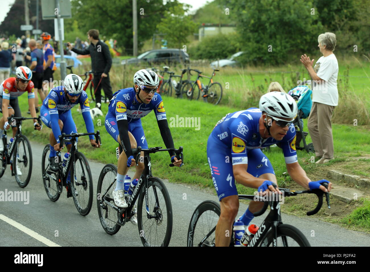 Timsbury, Inghilterra. 4° settembre 2018. Stadio 3 del 2018 OVO Energy Tour della Gran Bretagna cycle race. Il pelaton portano fuori dal Team pavimenti Quick-Step insegue giù i principali quattro piloti della tappa come la gara passa attraverso Timsbury. Il grande tifo folla applaude i loro sforzi. La gara sulla testa verso i villaggi di alta Littleton, Farmborough Marksbury e. Credito carda Simon/Alamy Live News Foto Stock
