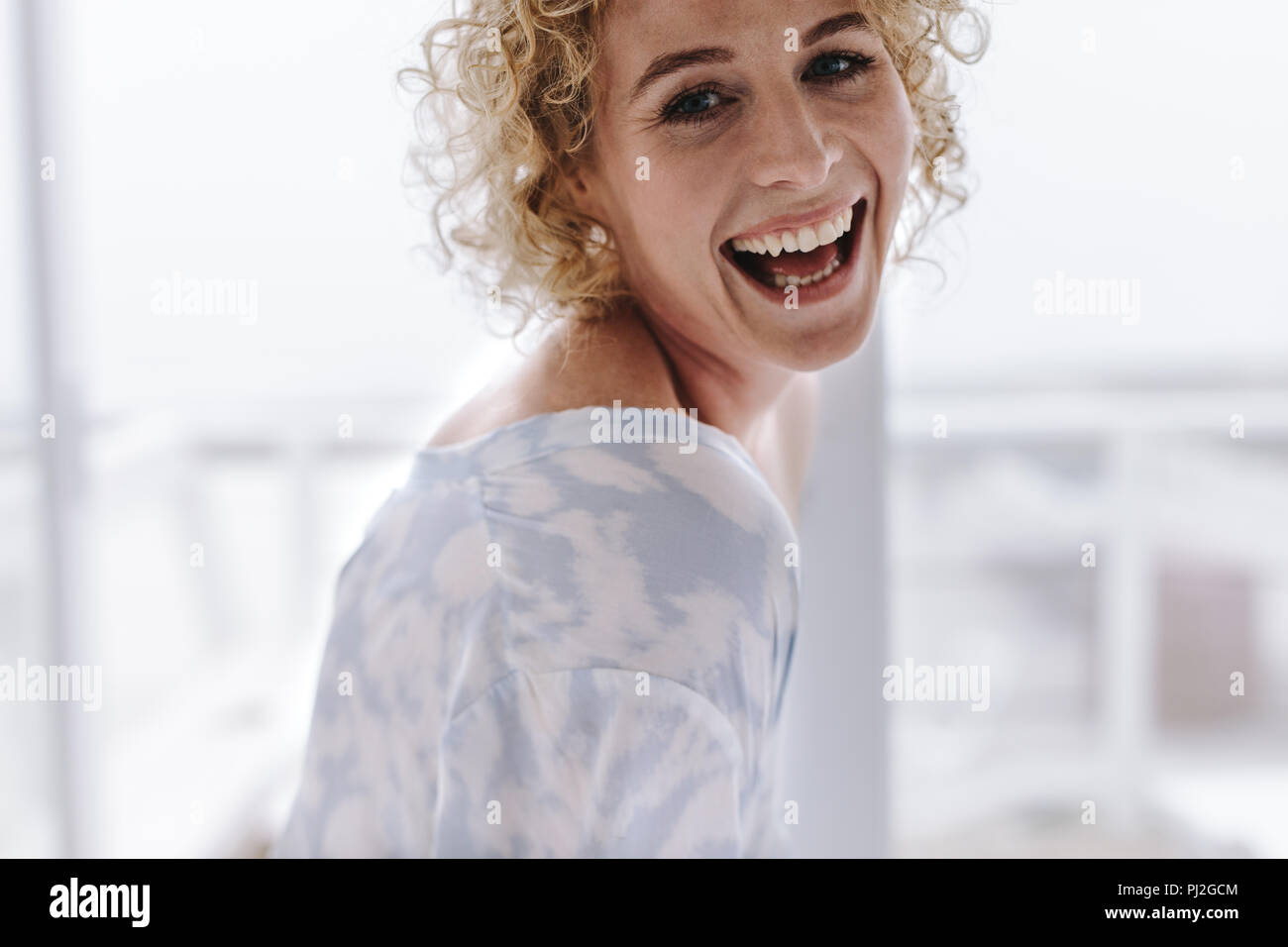 In prossimità di una donna a casa sorridente. Donna con parentesi marrone capelli ridendo. Foto Stock