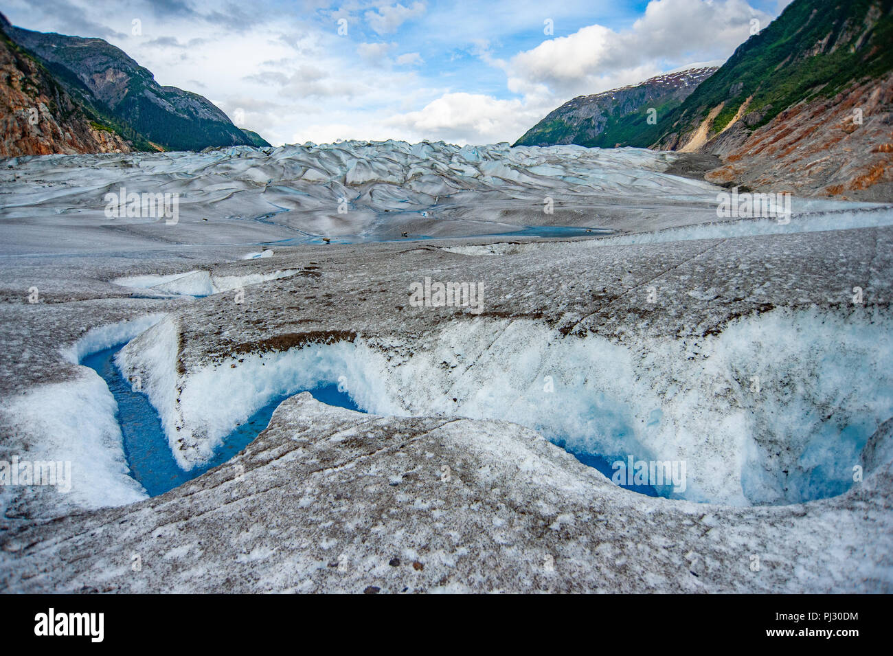 Glacier tour in elicottero - Juneau Alaska - nave da crociera escursione oltre il Juneau icefield atterraggio sul ghiacciaio Gilkey - fantastico blu acqua di disgelo glaciale Foto Stock