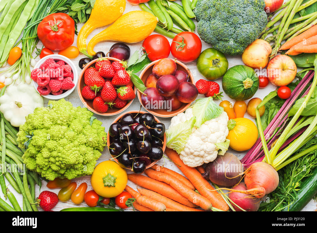 Frutta estiva verdure bacche sfondo, mele Ciliege Pesche Fragole Cavolo broccoli Cavolfiori squash Pomodori Carote cipolline barbabietola, vista dall'alto, il fuoco selettivo Foto Stock