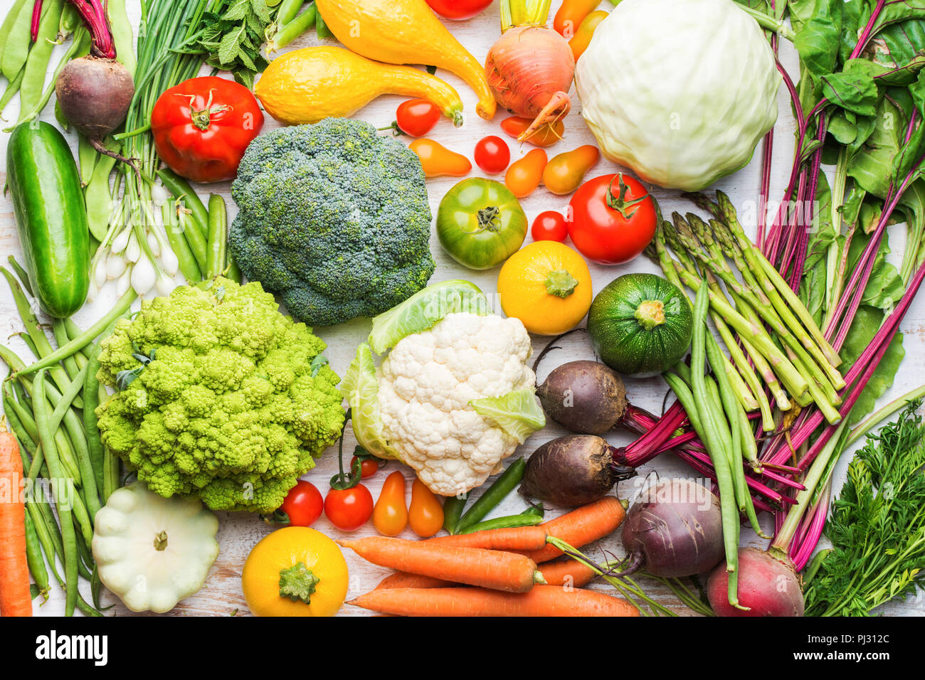 Colorate verdure organiche sfondo bianco sul tavolo di legno, sfondo sani, broccoli Cavolfiori Pomodori cipolline cetrioli carote, barbabietole, vista dall'alto, il fuoco selettivo Foto Stock