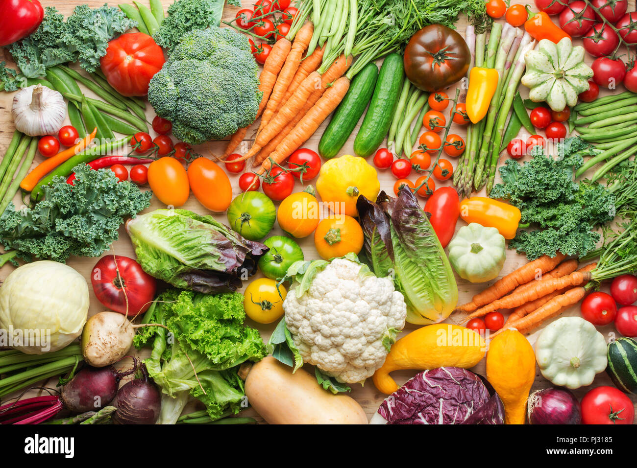 Assortimento di coloratissimi fresche verdure organiche su legno tabella di pino, cibo sano sfondo, vista dall'alto, il fuoco selettivo Foto Stock