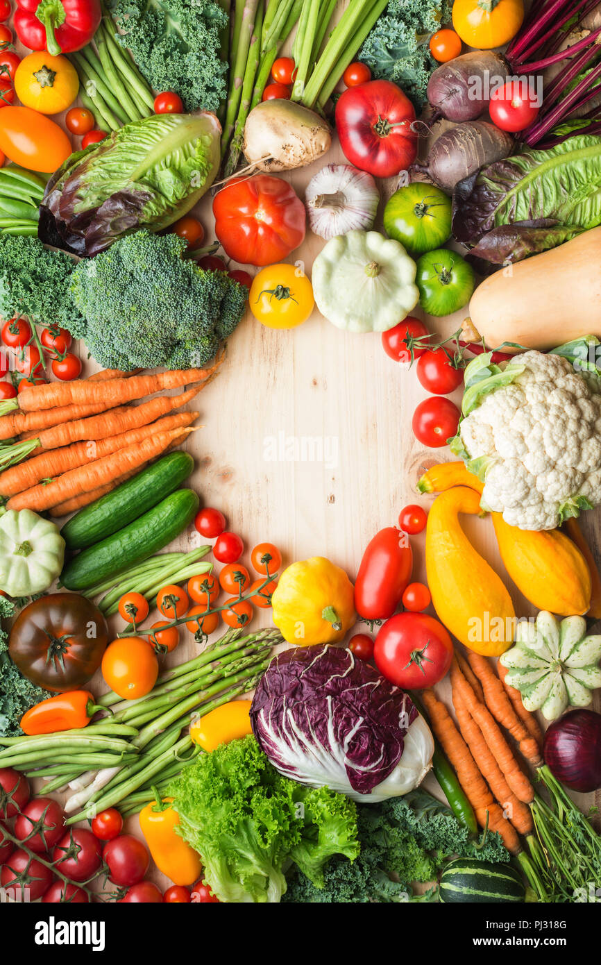 Prodotti freschi di fattoria e colorati di verdure su legno tabella di pino, sfondo sani, copiare lo spazio per testo in medio, vista dall'alto, verticale, il fuoco selettivo Foto Stock
