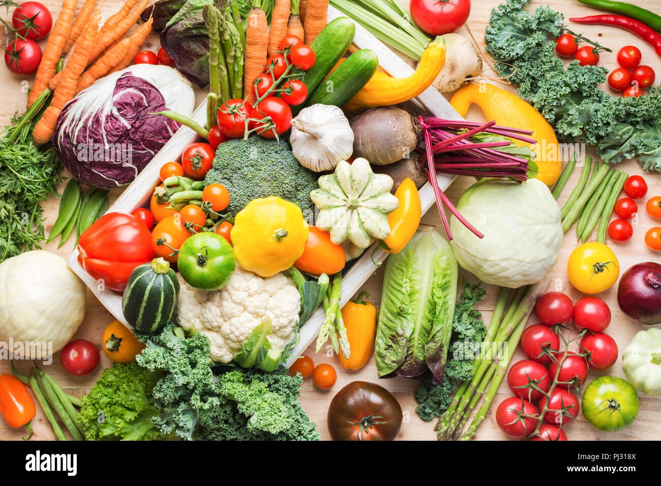 Assortimento di coloratissimi fresca verdura biologica in bianco sul vassoio in legno tabella di pino, cibo sfondo, vista dall'alto, il fuoco selettivo Foto Stock