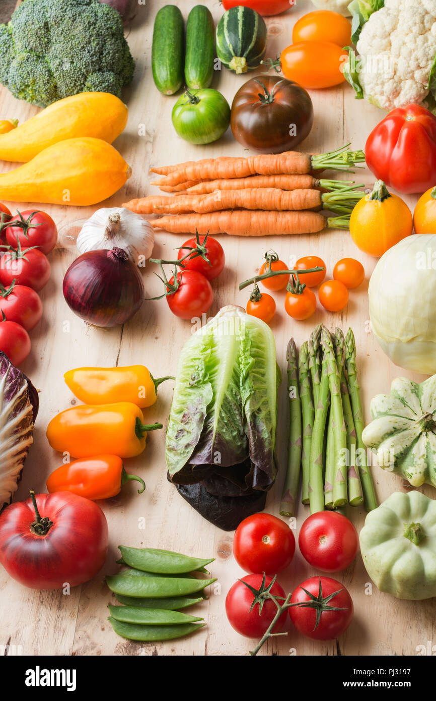 Assortimento di coloratissimi fresche verdure organiche su legno tabella di pino, cucina creativa lo sfondo in una griglia, verticale, il fuoco selettivo Foto Stock
