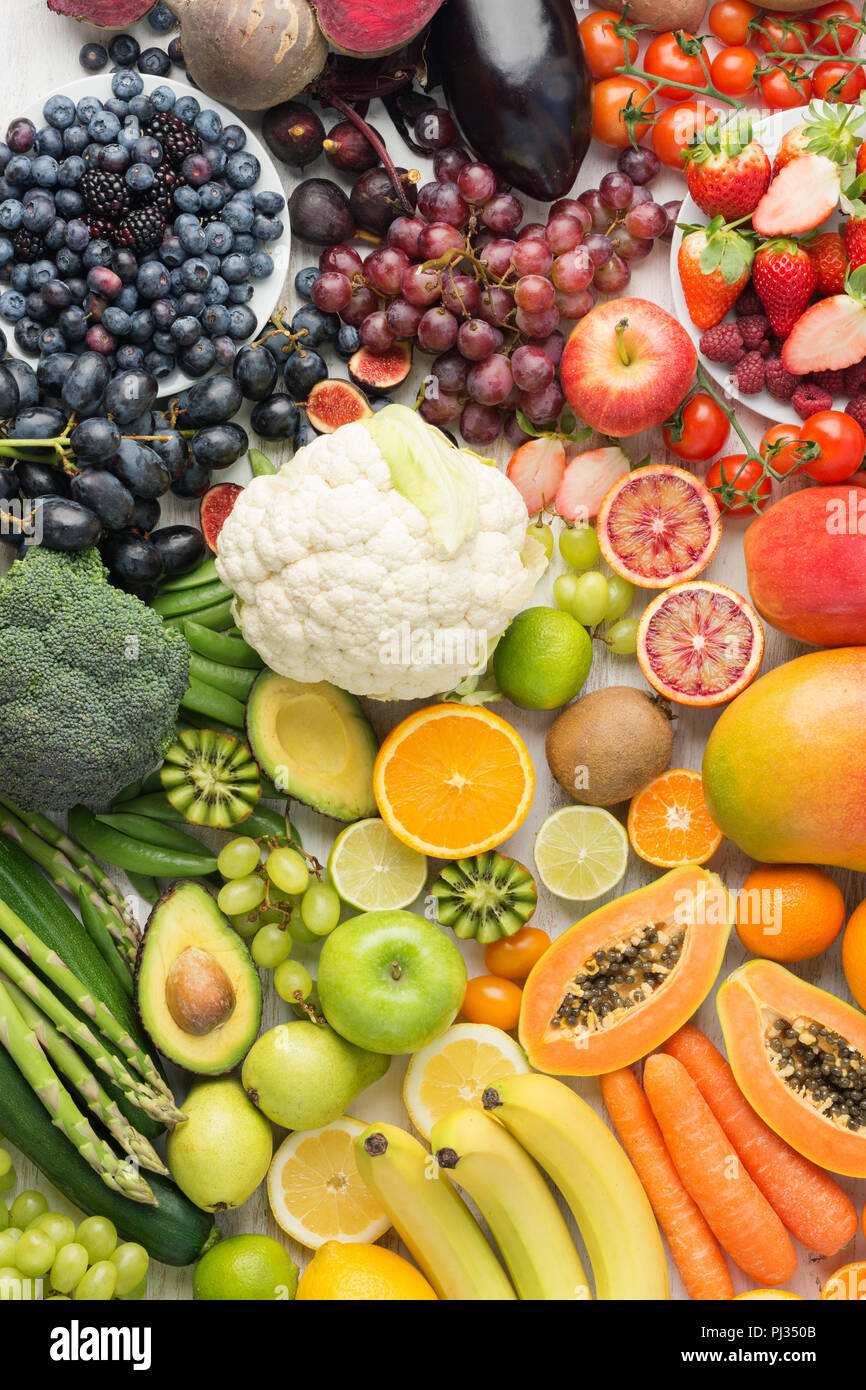 Mangiare sano sfondo, assortimento dei diversi tipi di frutta e verdura in arcobaleno di colori sul bianco tavola disposta in un rettangolo, vista dall'alto, il fuoco selettivo Foto Stock