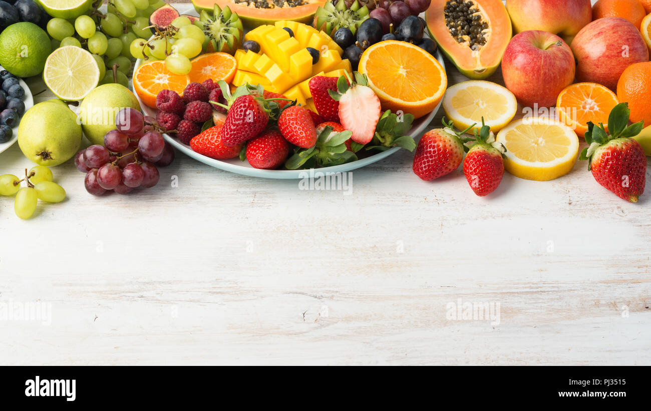 La frutta e la verdura fresca in arcobaleno di colori su off tavola bianco, copia di spazio, il fuoco selettivo Foto Stock
