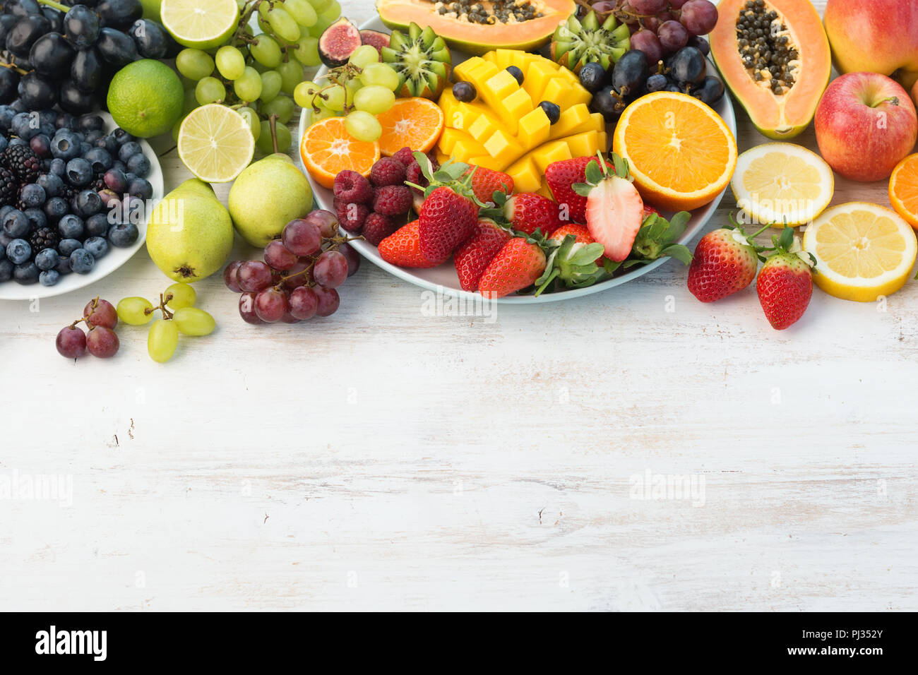 La frutta e la verdura fresca in arcobaleno di colori su off tavola bianco, copia di spazio, il fuoco selettivo Foto Stock
