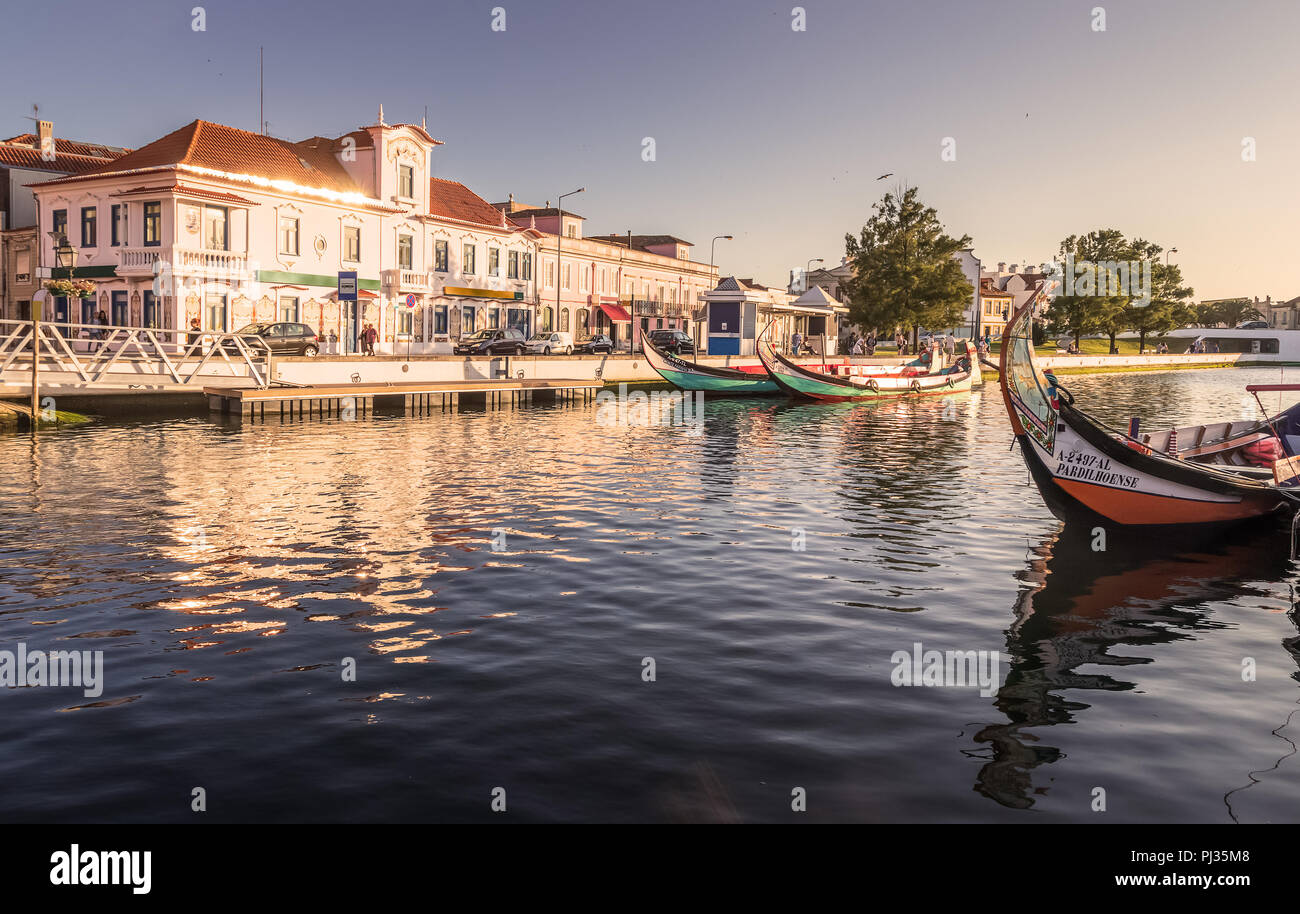 Canale centrale in Aveiro, Portogallo, con alcune barche tradizionali, noto come moliceiros e vecchie case di sfondo. Foto Stock