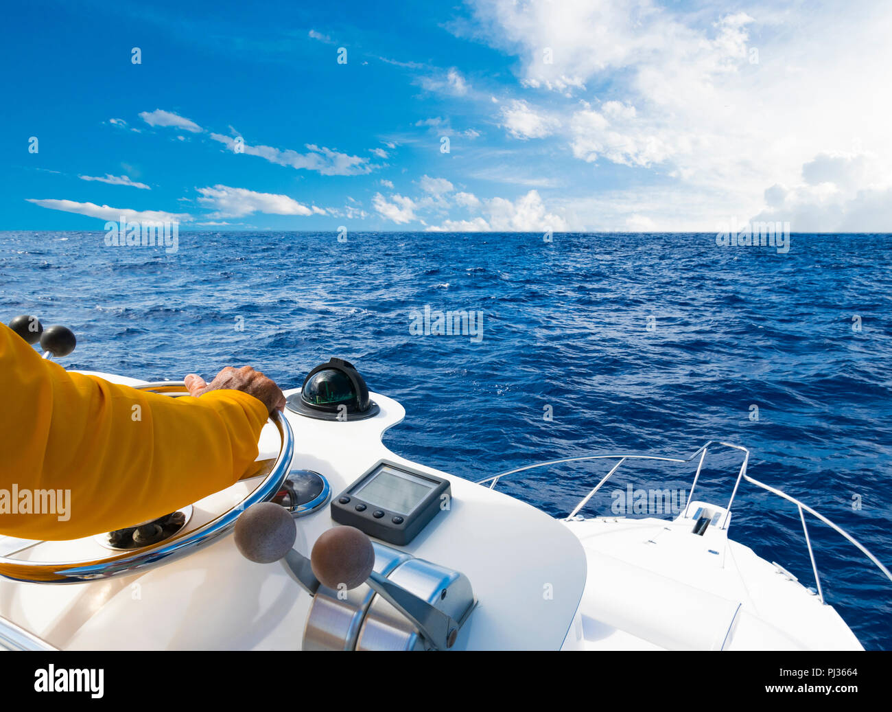 Mano del capitano sul volante di imbarcazione a motore nell'oceano blu  durante la giornata di pesca. Successo il concetto di pesca. Ocean yacht  Foto stock - Alamy