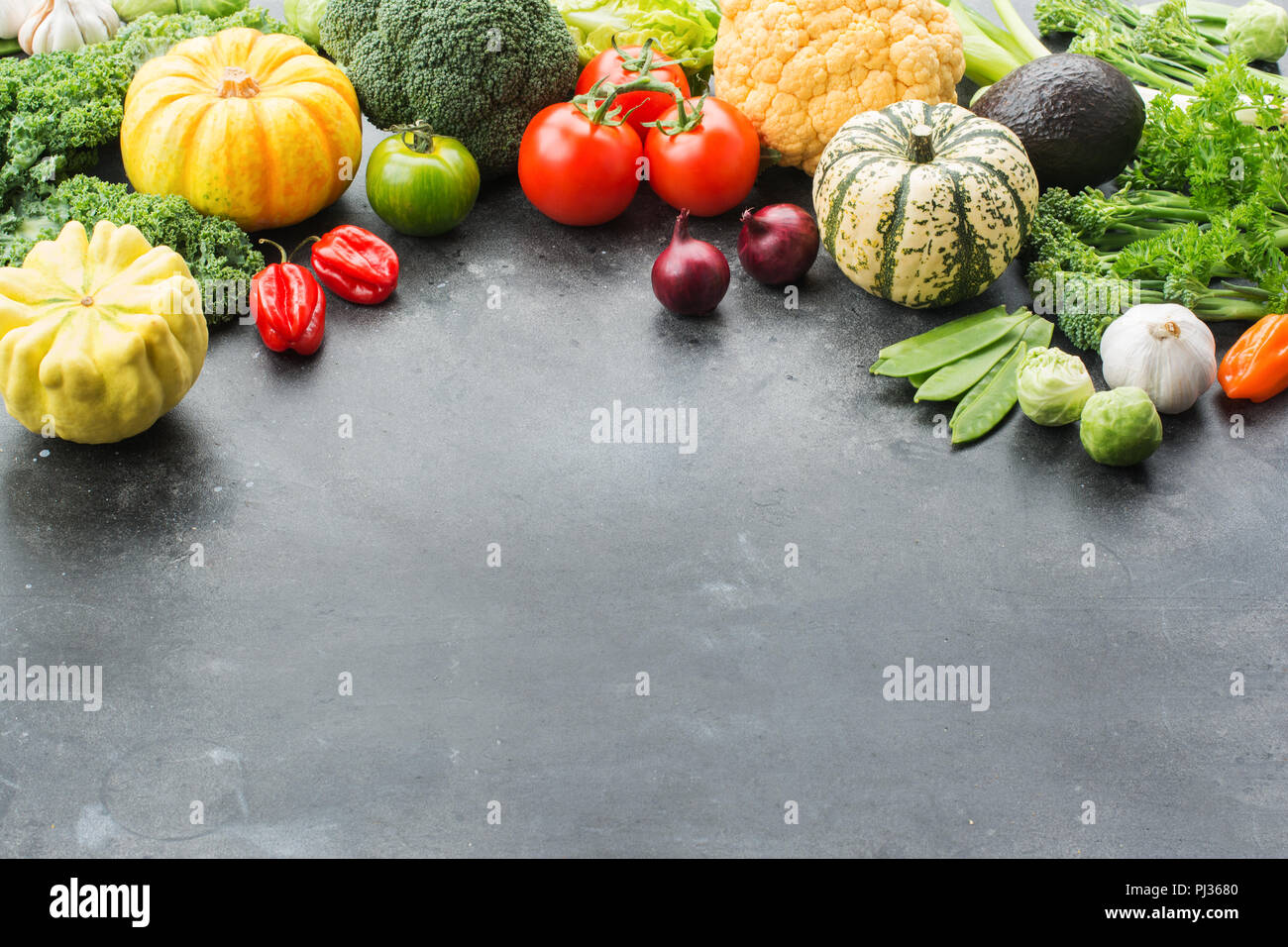 Al di sopra di vista di verdure sul grigio scuro su sfondo nero, copia spazio per il testo al di sotto, il fuoco selettivo Foto Stock