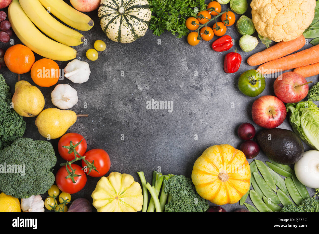 Assortimento di verdure e frutti disposti in un cerchio su sfondo grigio scuro, copiare lo spazio per testo in medio, vista dall'alto, il fuoco selettivo Foto Stock